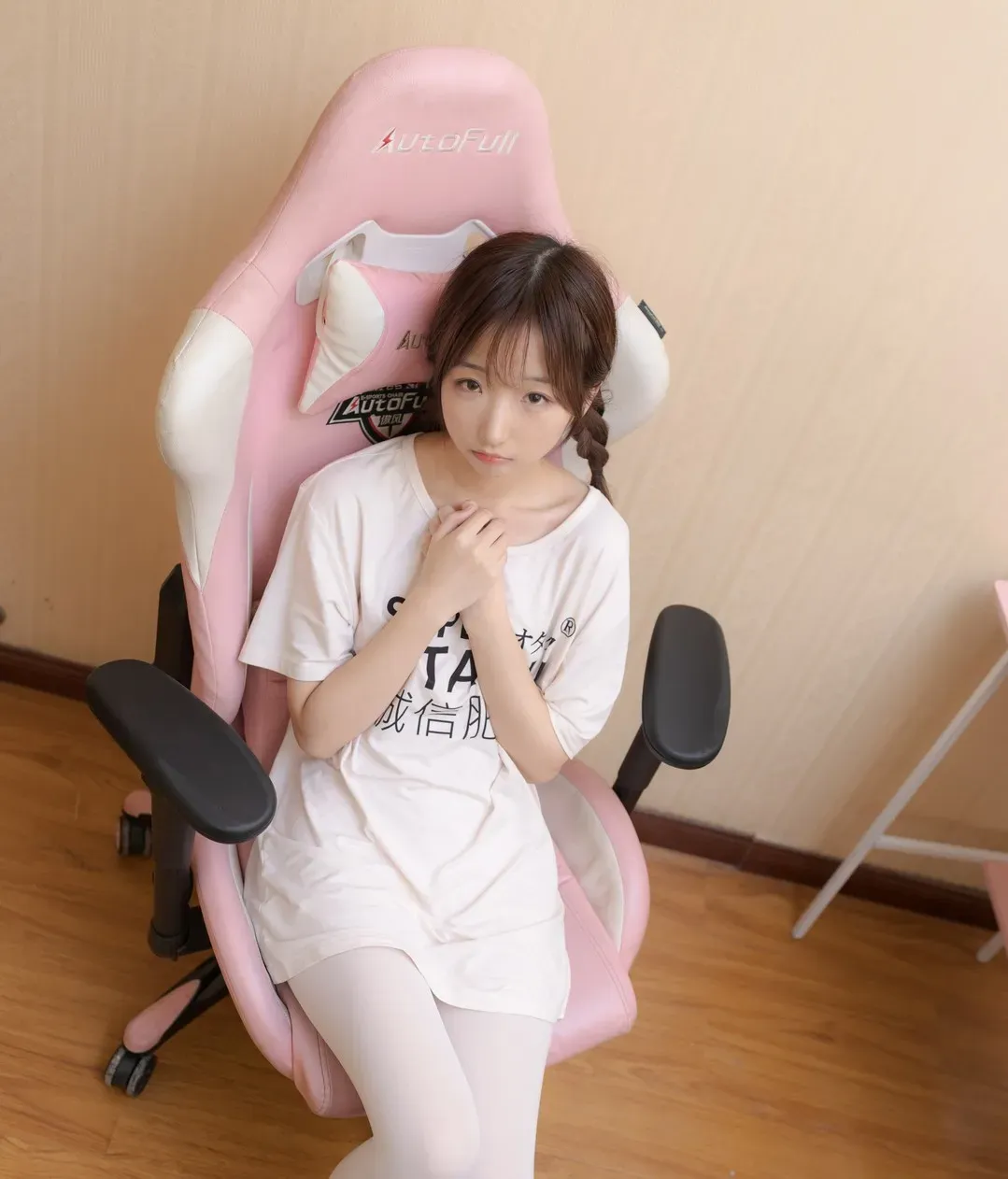 少女秩序角色写真风格作品整理 粉白色空间中的人物坐在粉色椅子上，穿白色上衣展示清淡风格造型