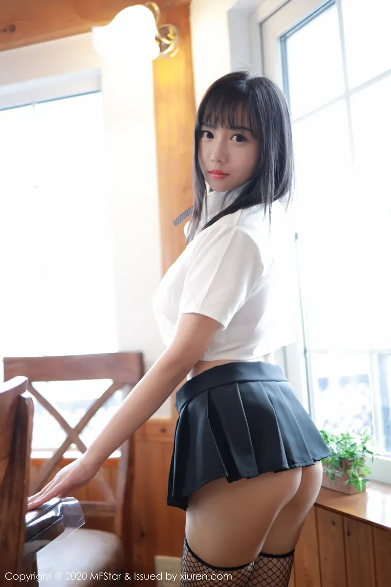 chloe霏霏角色写真风格作品介绍 人物穿白色上衣和深色裙装站在室内窗边的照片