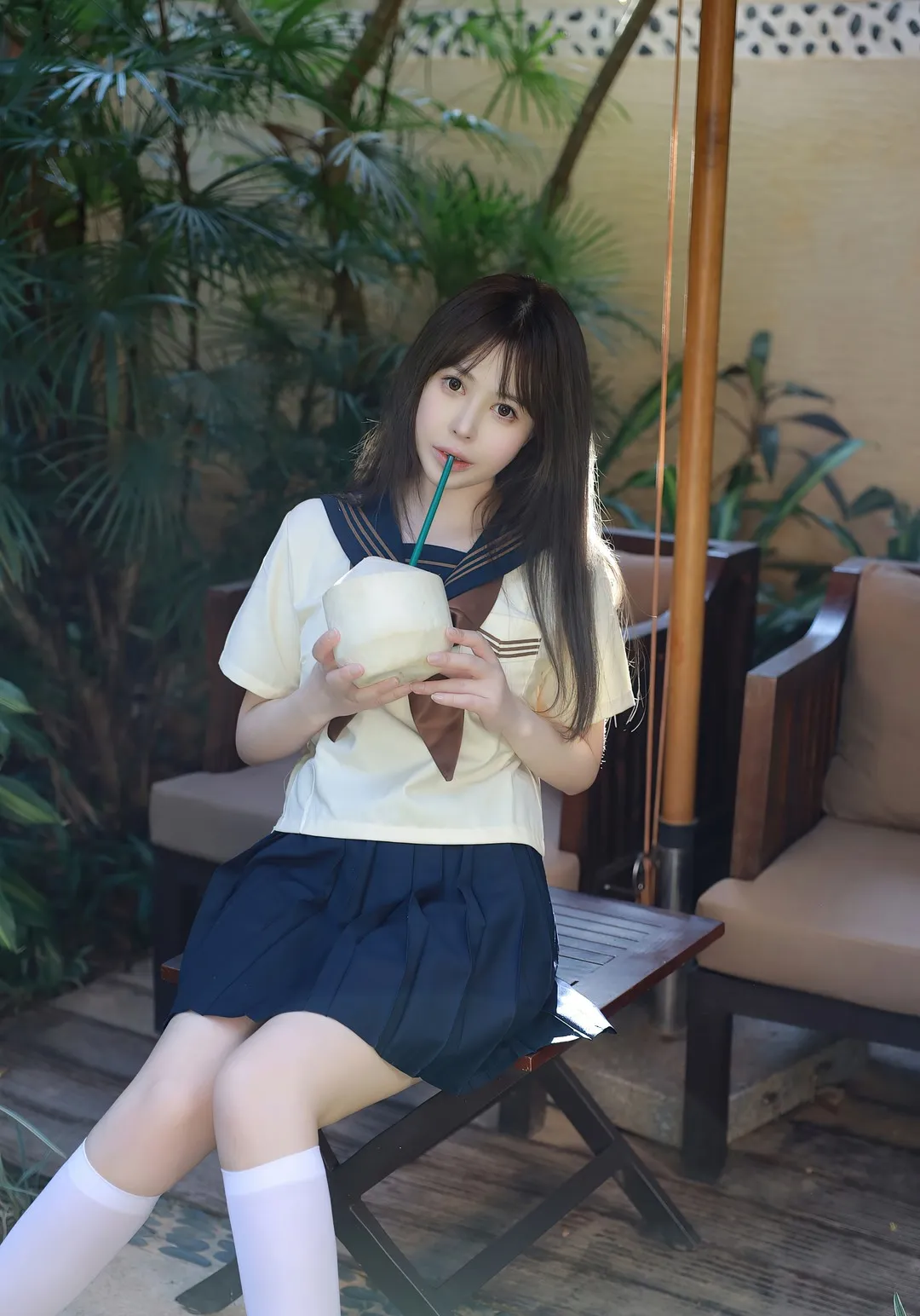 Evelyn艾莉角色写真风格作品整理 人物穿着校园风服装坐在户外空间并手持饮品