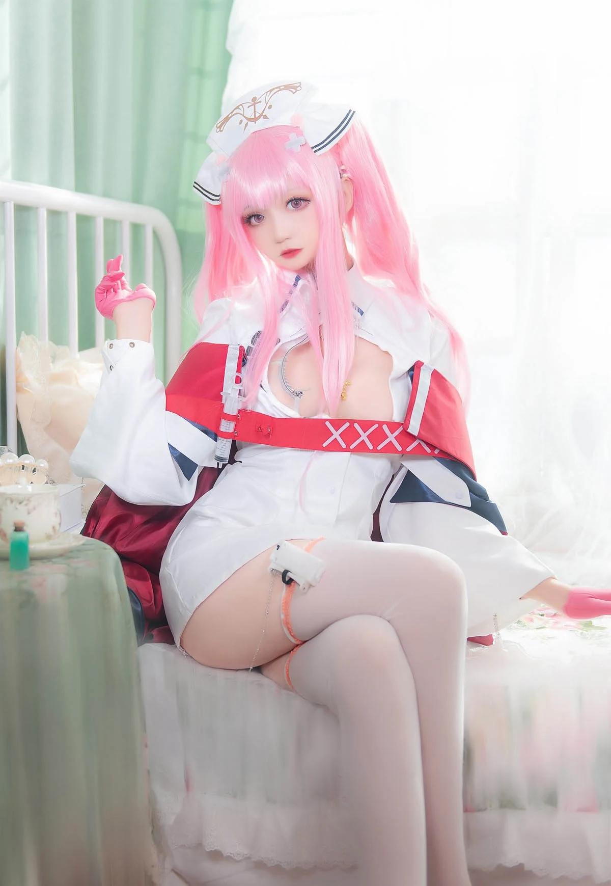 小野寺地瓜cosplay角色写真风格作品参考 粉色长发搭配白色制服和红色装饰的角色扮演造型,人物坐在室内环境中,呈现幻想系角色风格。