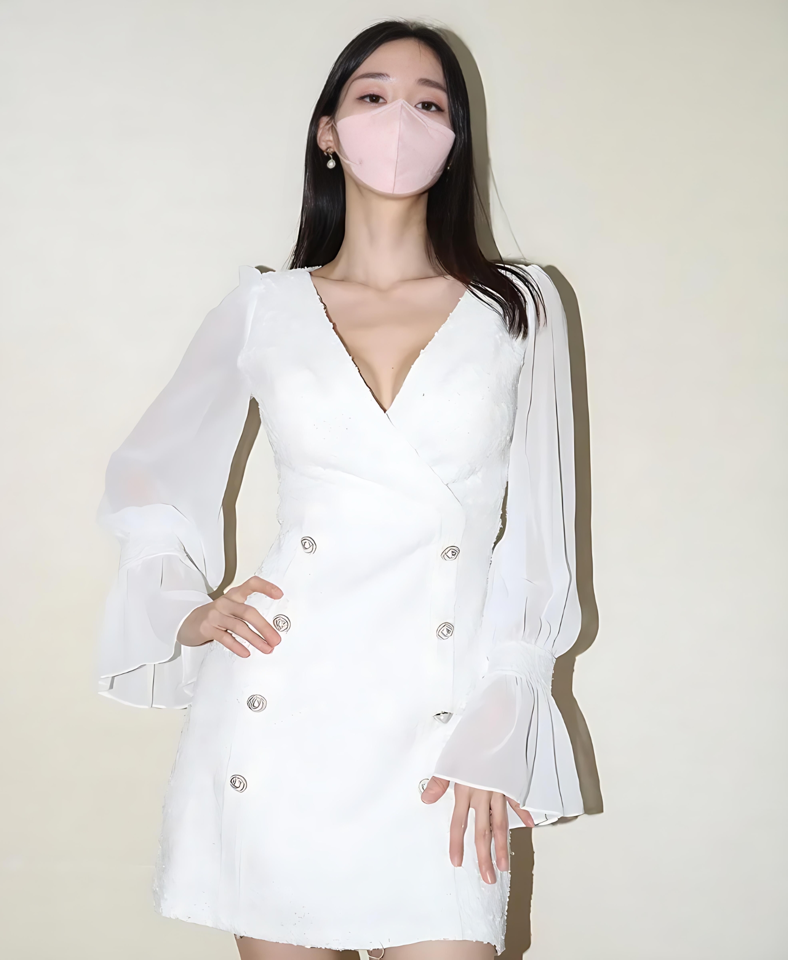伊芙琳Evelyn衬衫短裙穿搭题材作品参考 伊芙琳Evelyn黑色长发，穿白色长袖连衣裙并佩戴粉色口罩，正面站在浅色墙前