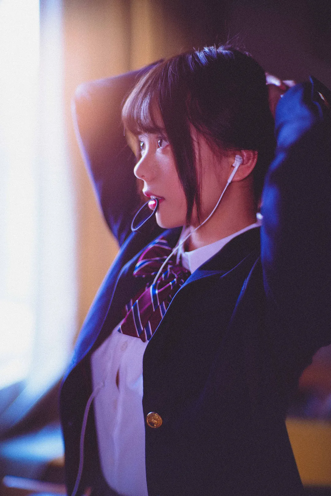小野妹子w cosplay角色写真风格作品参考 深色制服外套搭配浅色内搭的角色扮演造型,人物侧身坐在室内环境中,发型与服饰突出校园题材特点。