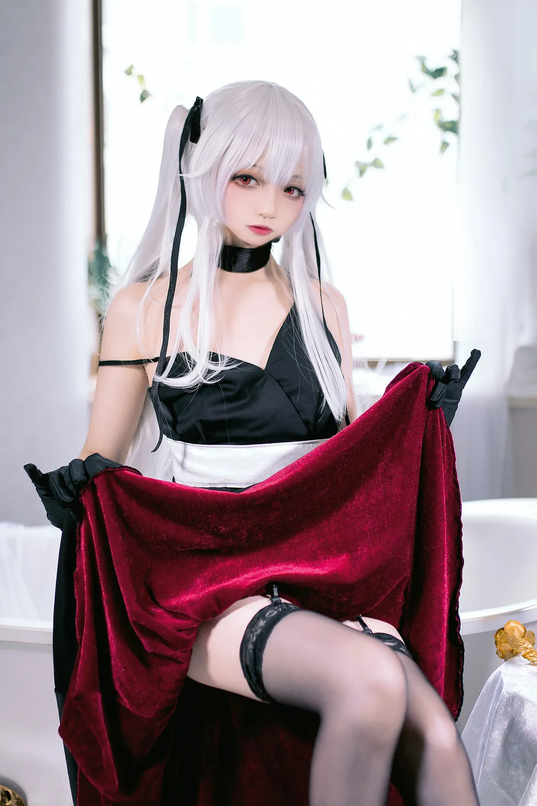 小野寺地瓜cosplay角色写真风格作品参考 白色双马尾搭配黑色服装和红色布料的角色造型,人物位于明亮室内环境中,呈现冷暖对比风格。