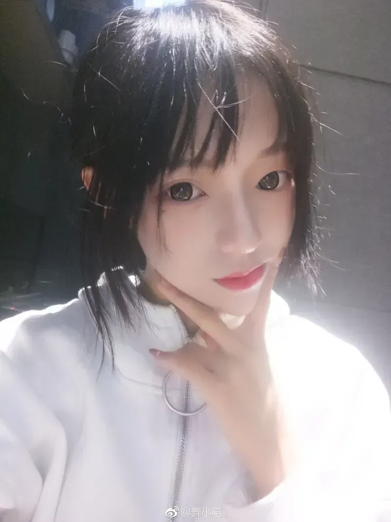 身穿白色拉链立领卫衣单手托腮的正面仰角自拍