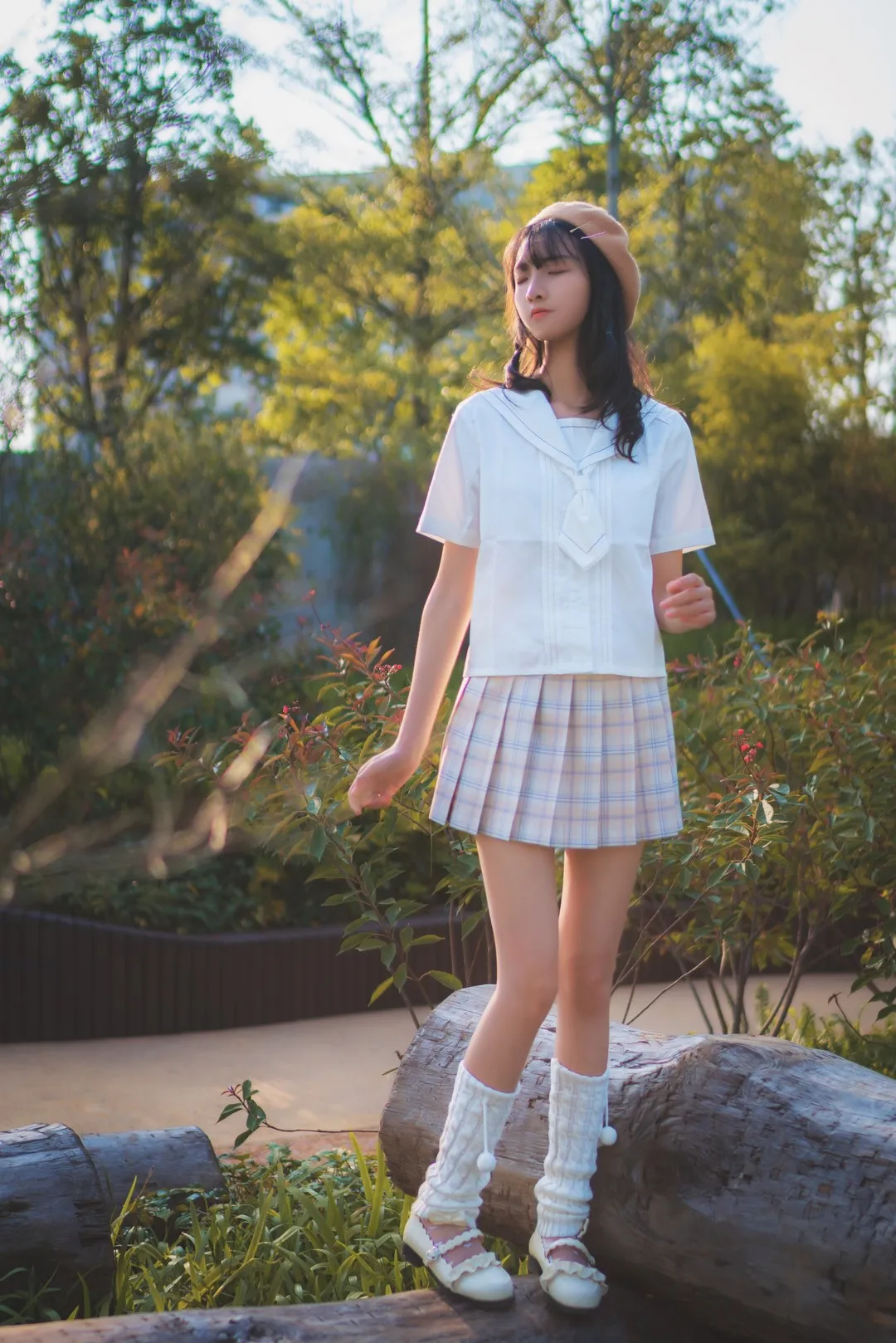 西瓜少女佩戴贝雷帽双脚踩在横置原木上站立