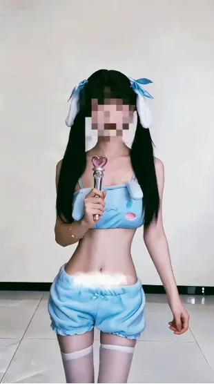 双马尾配蓝色丝带女性身穿浅蓝卡通主题分体衣持心形道具