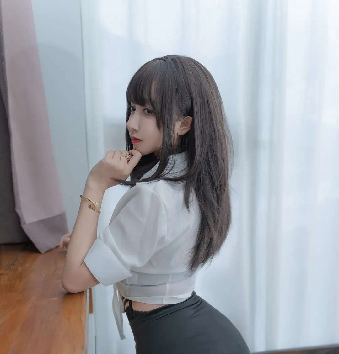 白衬衫与黑色短裙靠桌侧姿