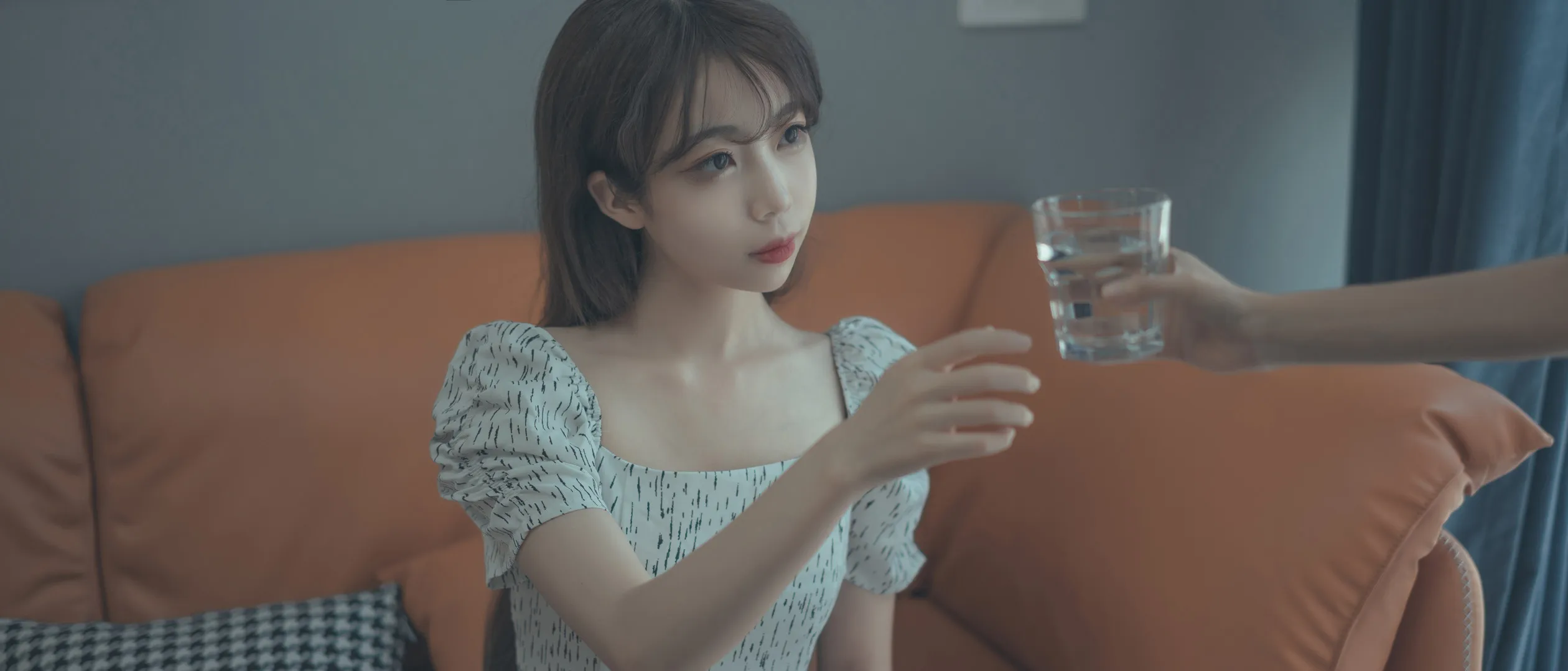 杏仁曲奇女仆造型与游戏角色写真风格参考 浅色泡泡袖连衣裙人物坐在橙色沙发上伸手接玻璃杯的室内中近景