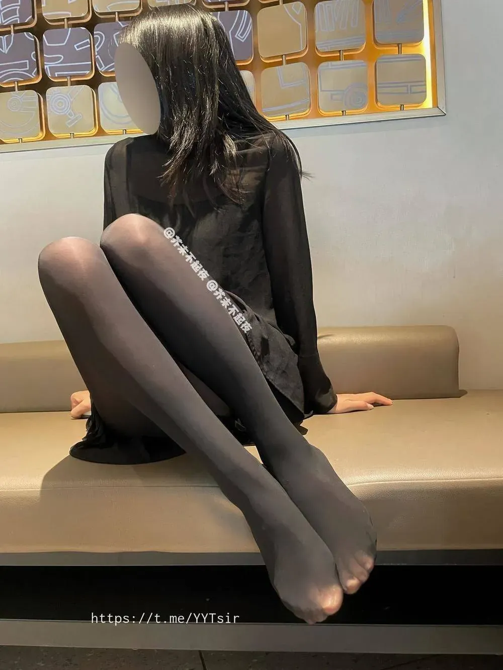 芥末不起夜身着黑色长袖连身裙坐在浅色长凳上的中景姿态