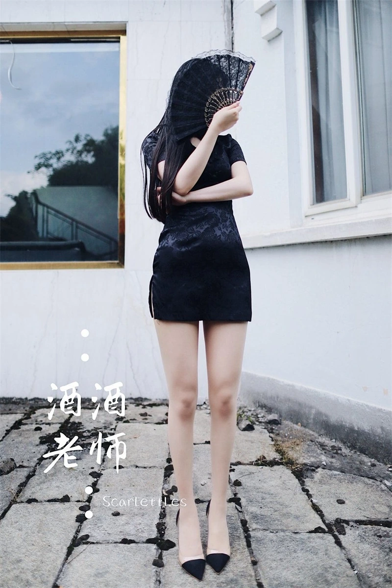 户外天台直立站姿展示黑色暗纹短旗袍与蕾丝折扇遮面