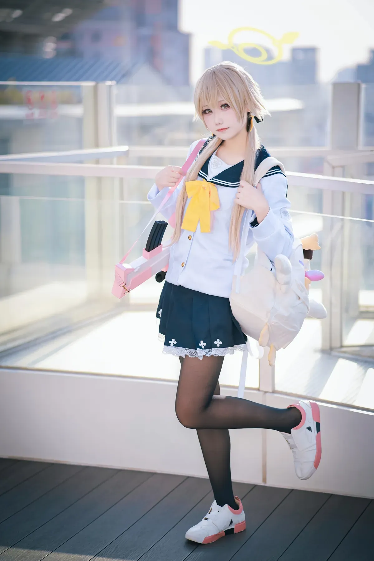 穿着蓝白水手服单腿站立在室外玻璃护栏旁的全身姿态