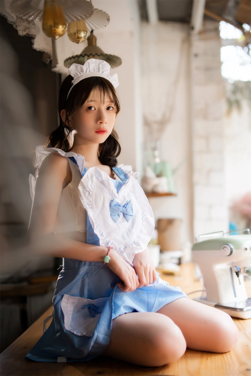 清青琴玖cosplay角色风格作品参考 室内环境中身穿蓝白色女仆风服装坐姿拍摄的照片