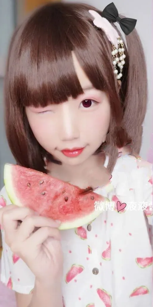 液液酱yeye角色扮演专题 棕色齐刘海短发搭配黑色蝴蝶结发饰和白底西瓜印花上衣,手持西瓜的近景人像